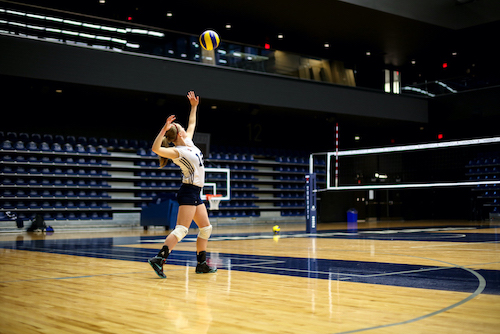 Varsity volleyball player Kate Lonergan serves the ball.