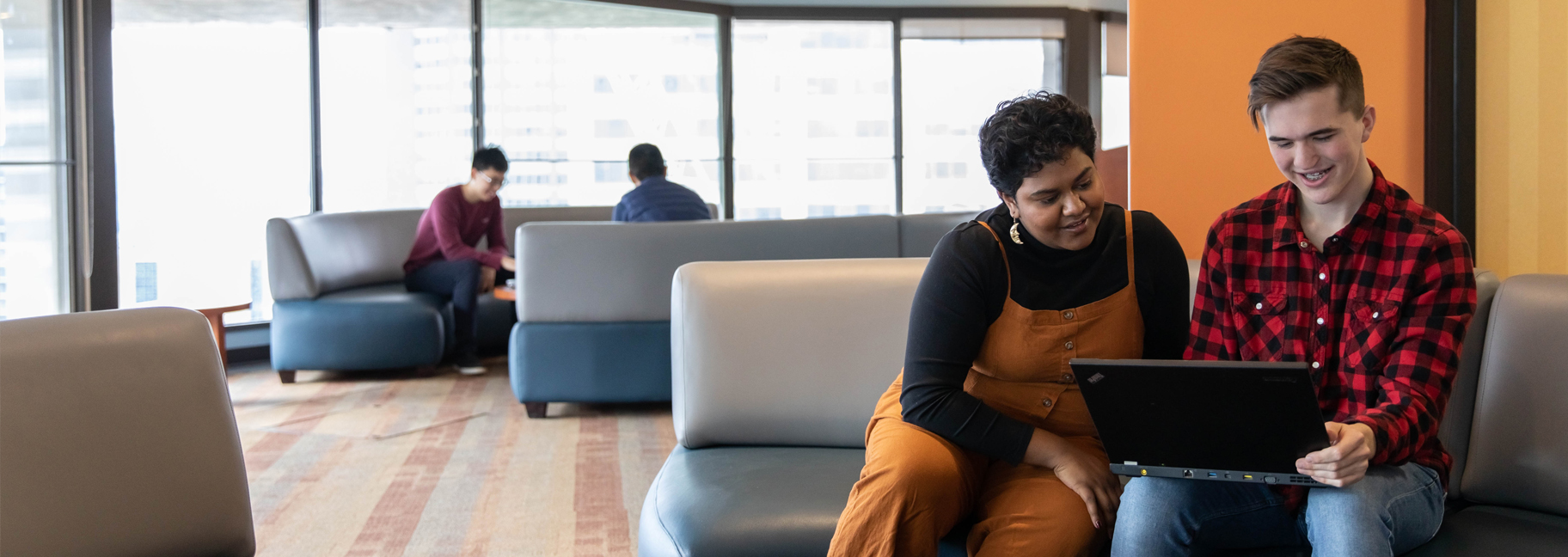 two students looking at a laptop