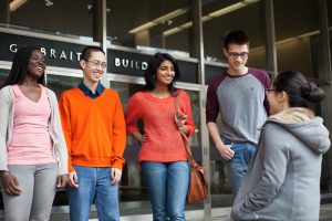 A group of students stand in front of the Galbraith Building.