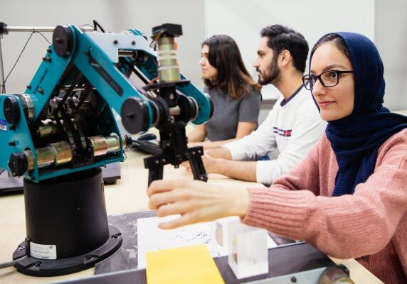 A student operating a small machine.